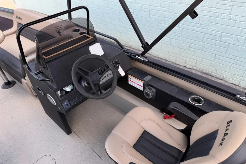 Slide: The Image of 2026 SeaArk Big Easy boat interior with steering wheel and beige seating. - 12