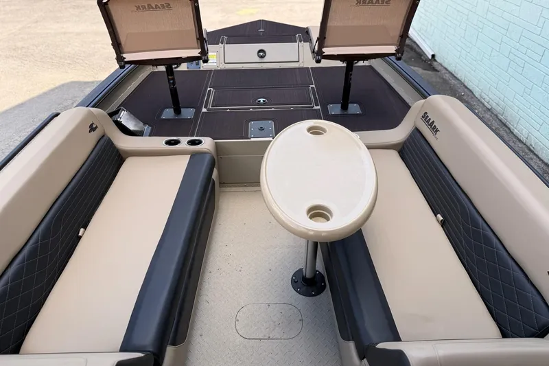 Slide: The Image of 2026 SeaArk Big Easy boat interior with seating and table, featuring cup holders. - 8
