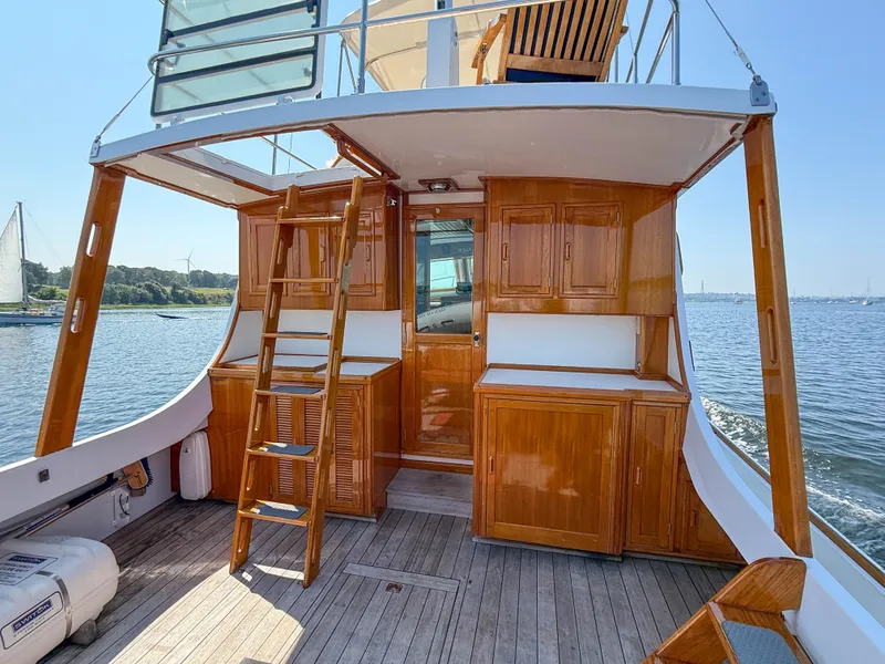 Slide: The Image of Wooden interior of 1984 Wilbur 38 boat with ladder, cabinets, and ocean view. - 17