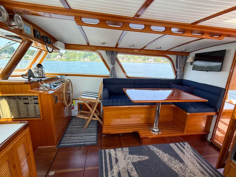 Slide: The Image of Interior of 1984 Wilbur 38 boat with wooden finish, blue seating, and steering wheel. - 19