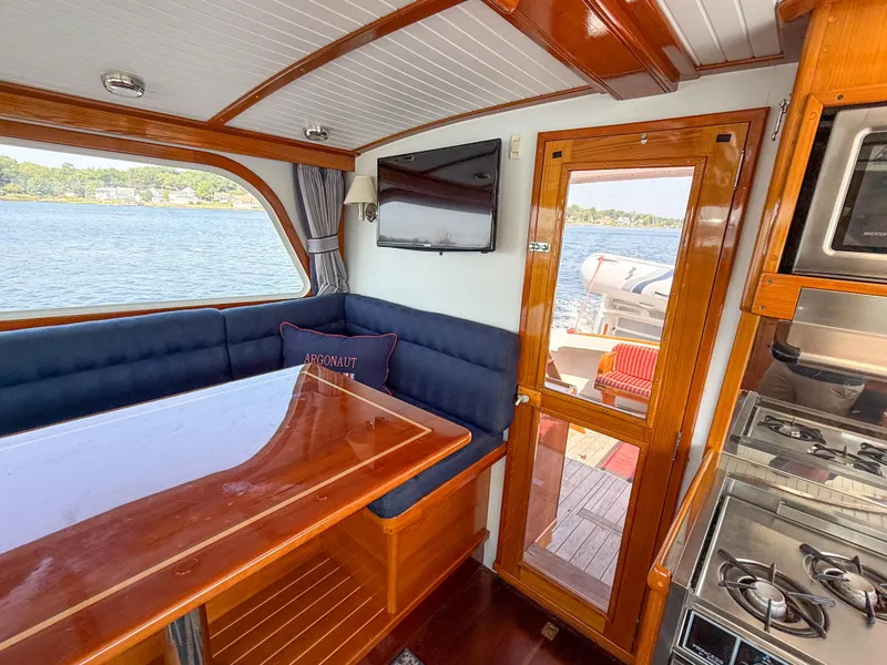 Slide: The Image of Interior of 1984 Wilbur 38 boat with dining area, stove, and scenic water view. - 21