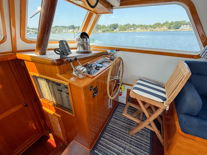 Slide: The Image of Helm of 1984 Wilbur 38 boat with wooden steering wheel and striped chair. - 23