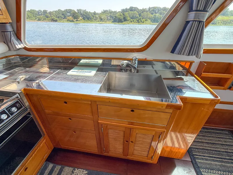 Slide: The Image of Interior of 1984 Wilbur 38 boat with wooden cabinetry and stainless steel sink. - 30