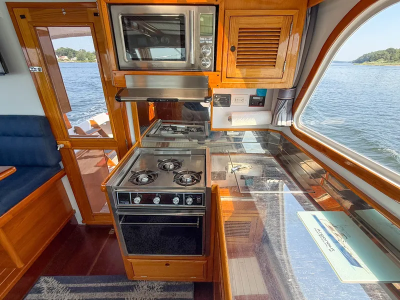 Slide: The Image of Interior of 1984 Wilbur 38 boat with kitchen, stove, and scenic water view. - 31