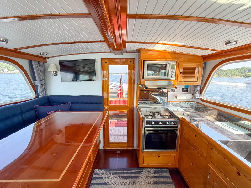 Slide: The Image of Interior of 1984 Wilbur 38 yacht with kitchen, dining area, and scenic water view. - 33