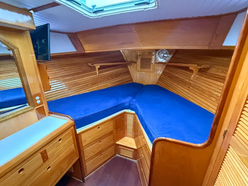 Slide: The Image of Cozy cabin interior of 1984 Wilbur 38 boat with blue bedding and wooden finish. - 35