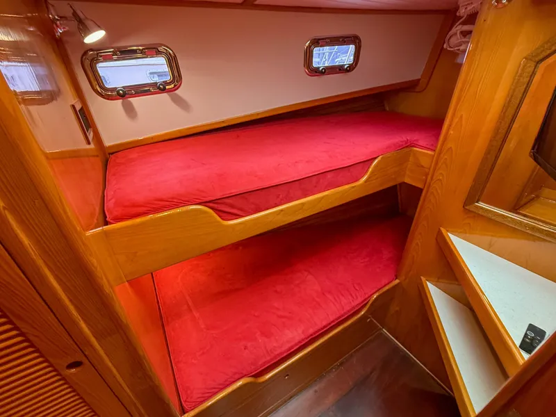 Slide: The Image of Cozy cabin with red bunk beds in a 1984 Wilbur 38 boat. - 39