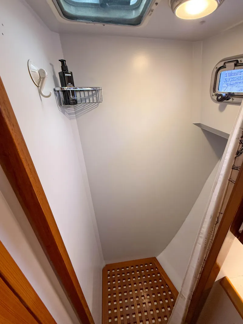 Slide: The Image of Compact shower area in 1984 Wilbur 38 boat with wooden floor and skylight. - 43