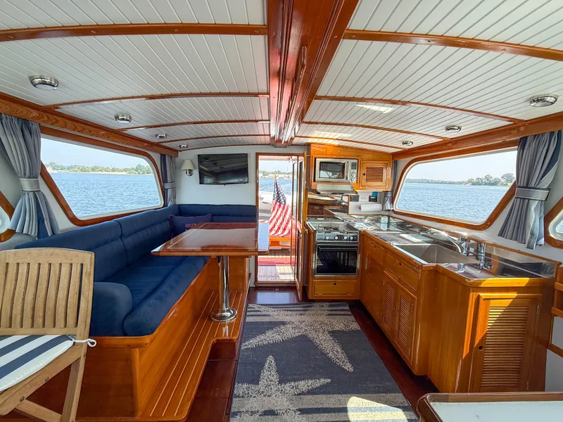 Slide: The Image of Luxurious interior of a 1984 Wilbur 38 yacht with elegant wood finishes and scenic water views. - 44