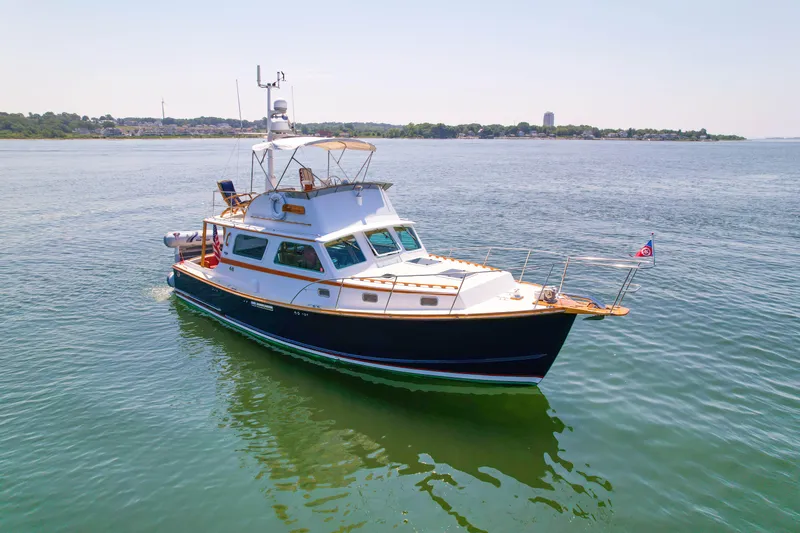 Slide: The Image of Classic 1984 Wilbur 38 boat on calm water, showcasing elegant design and craftsmanship. - 5