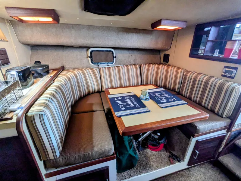Slide: The Image of 1981 Silverton 37 Convertible interior with striped seating and dining table. - 24