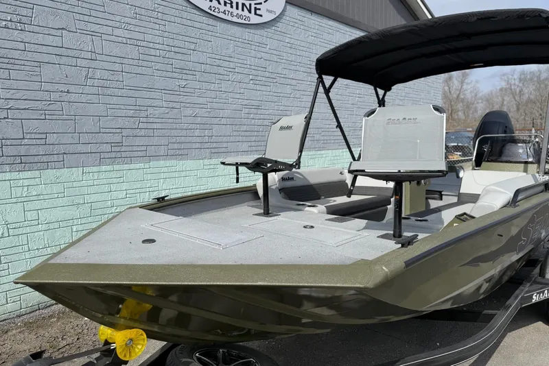 Slide: The Image of 2026 SeaArk Easy 200 boat with canopy and seating, parked outdoors. - 3