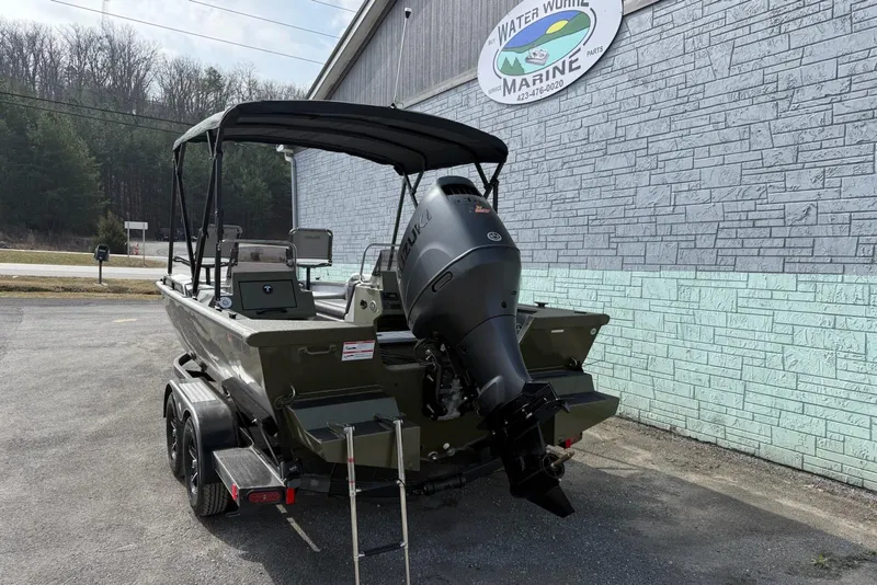 Slide: The Image of 2026 SeaArk Easy 200 boat with outboard motor parked outside a marine shop. - 5
