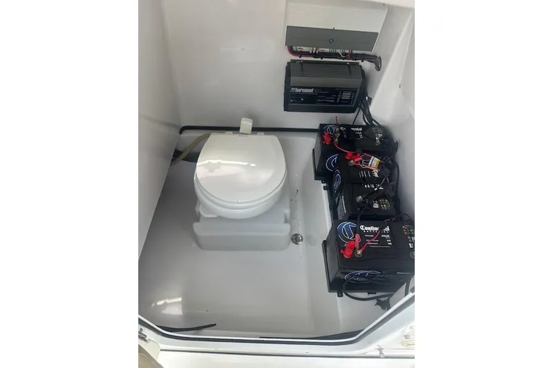 Slide: The Image of 2017 Sportsman Masters 267 Bay Boat interior with toilet and battery setup. - 13