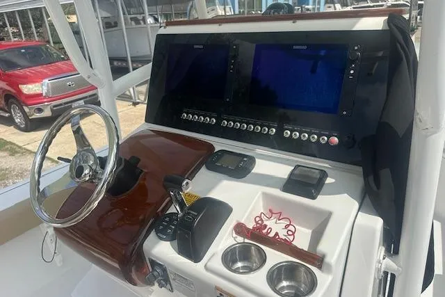 Slide: The Image of 2017 Sportsman Masters 267 Bay Boat dashboard with dual screens and steering wheel. - 19