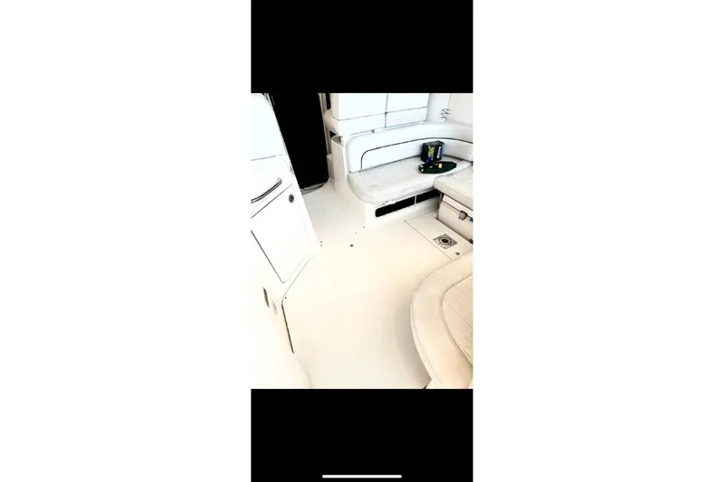 Slide: The Image of Interior of a 2005 Bayliner 305 boat, featuring white seating and clean design. - 11