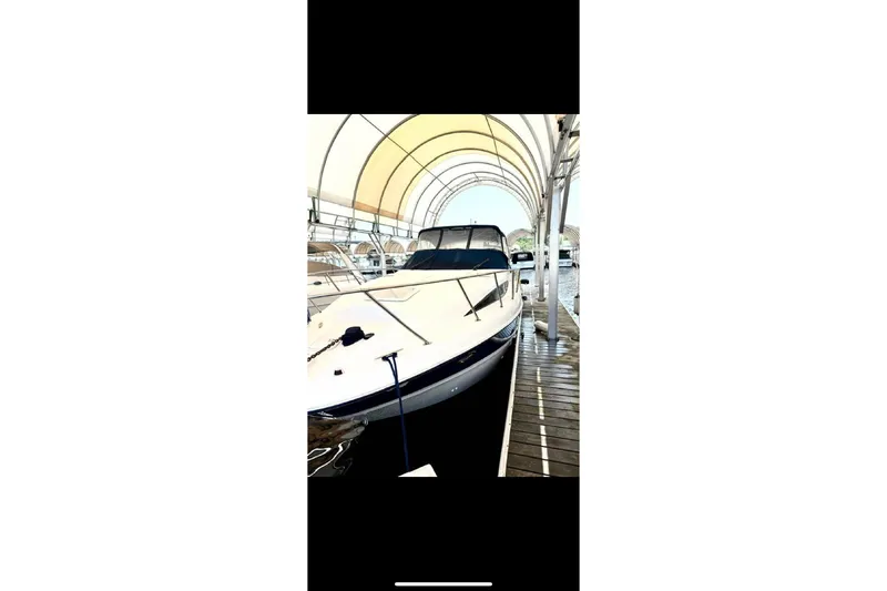 Slide: The Image of 2005 Bayliner 305 boat docked under canopy, side view. - 12