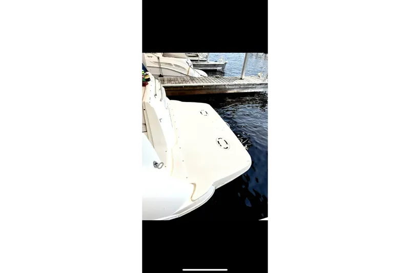 Slide: The Image of 2005 Bayliner 305 boat docked at marina, rear view showing swim platform. - 14