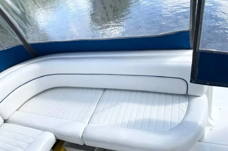 Slide: The Image of 2005 Bayliner 305 boat interior with white cushioned seating and blue trim. - 16