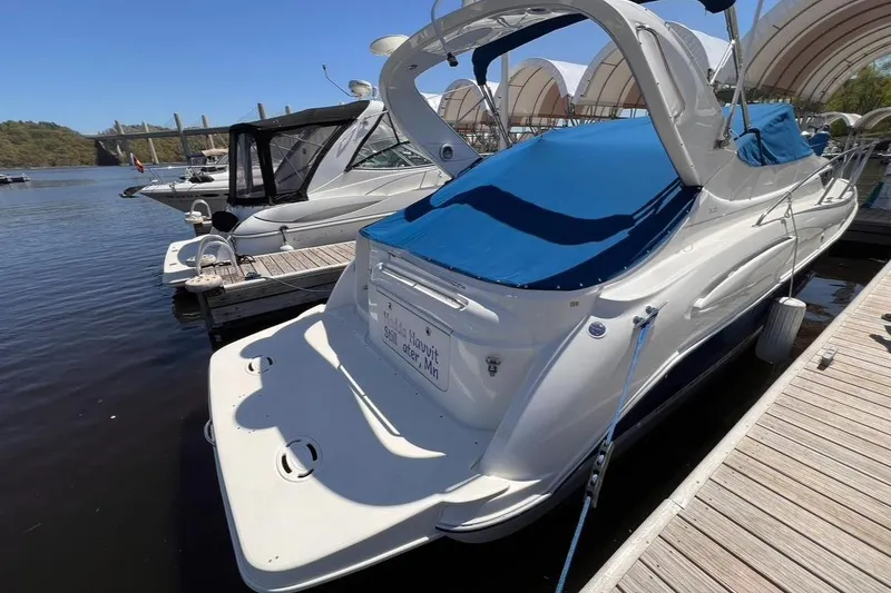 Slide: The Image of 2005 Bayliner 305 boat docked with blue cover, sunny day, marina setting. - 20