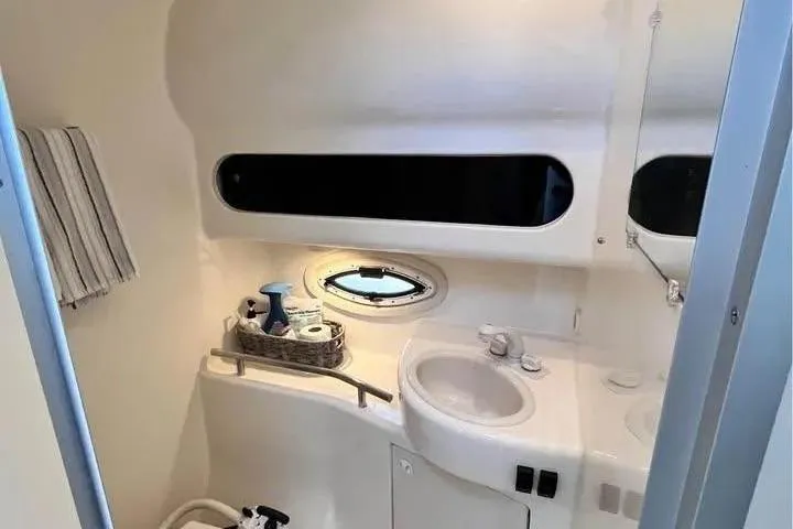Slide: The Image of 2005 Bayliner 305 boat bathroom with sink, porthole, and toiletries. - 22