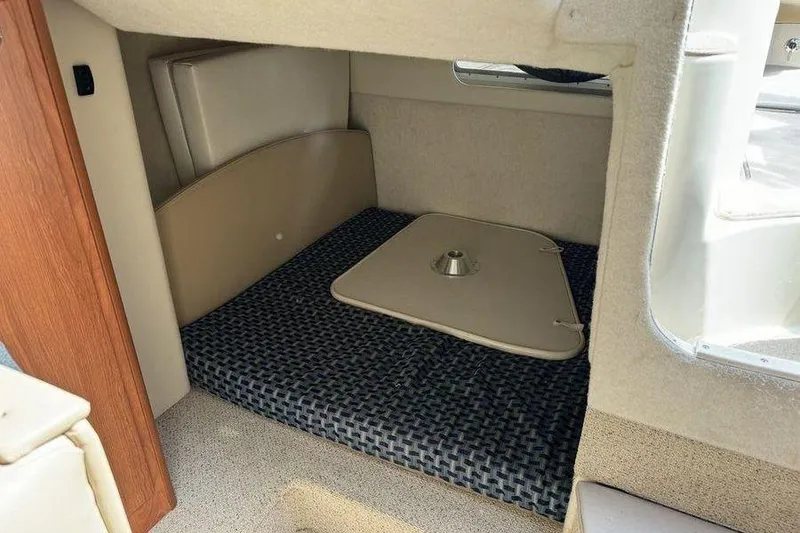 Slide: The Image of Interior cabin of 2005 Bayliner 305 boat with cushioned seating and table base. - 6