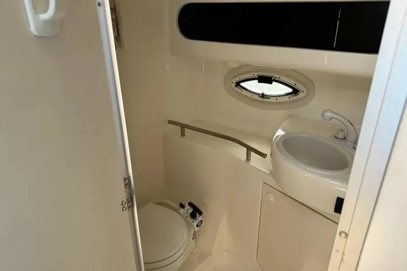 Slide: The Image of Bathroom interior of 2005 Bayliner 305 boat with toilet, sink, and porthole window. - 7