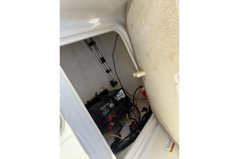 Slide: The Image of 2016 Bayliner 160 Bowrider battery compartment with wiring and storage space. - 12