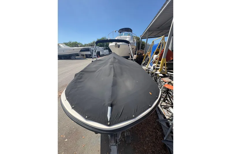 Slide: The Image of 2016 Bayliner 160 Bowrider with cover, parked in a marina under clear blue sky. - 3