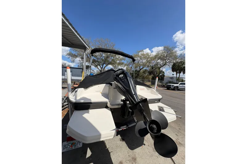 Slide: The Image of 2016 Bayliner 160 Bowrider boat with outboard motor, parked outdoors under clear sky. - 4