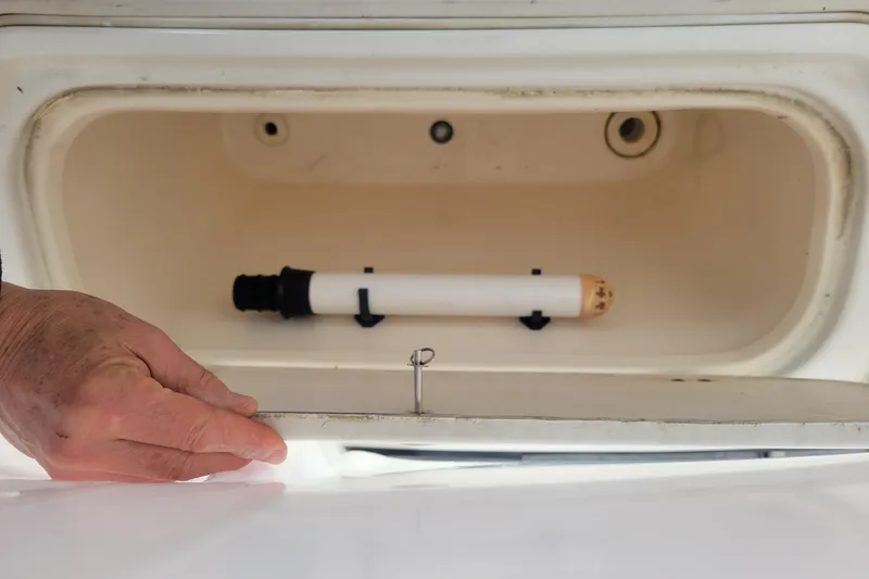 Slide: The Image of Hand opening storage compartment on 2001 Shamrock 22 Open Center Console boat. - 25