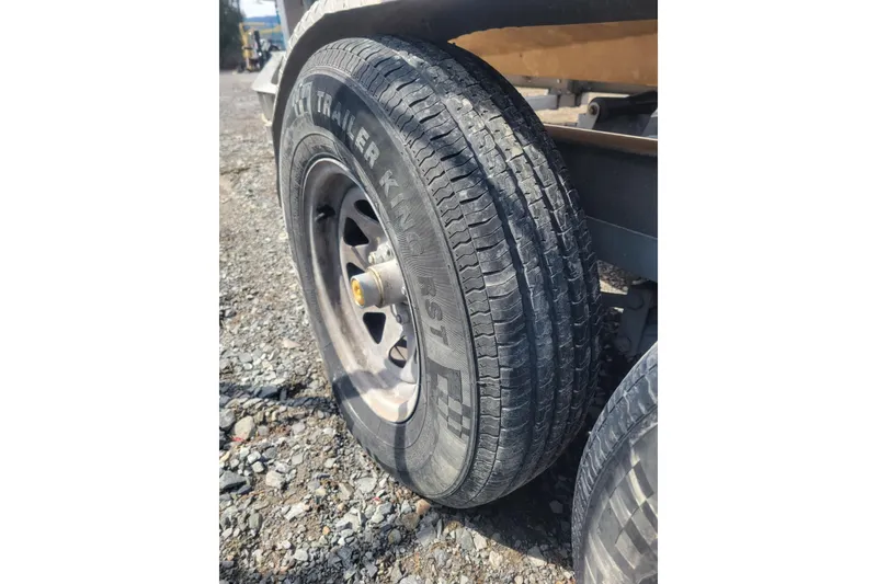 Slide: The Image of Trailer tire on Shamrock 220 Open, 2001 model, parked on gravel surface. - 31