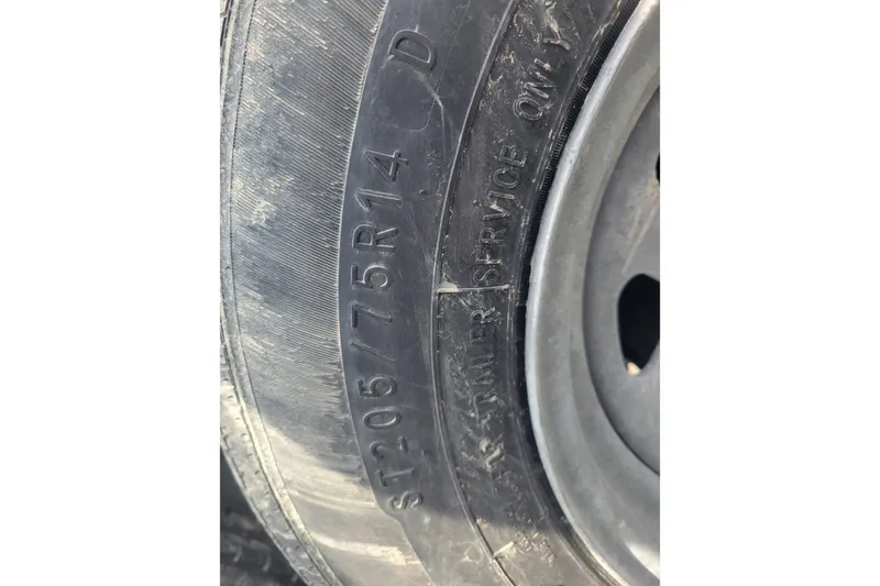 Slide: The Image of Close-up of a tire with markings "ST205/75R14" on a 2001 Shamrock 220 Open. - 32