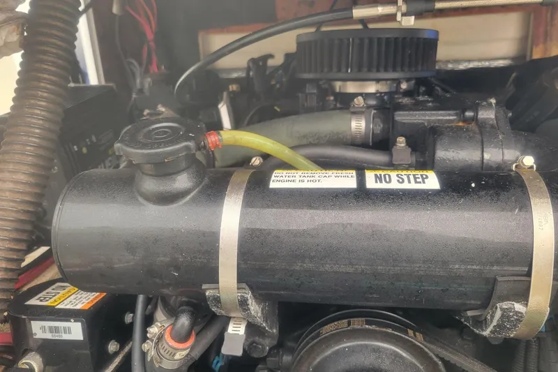 Slide: The Image of Engine compartment of a 2001 Shamrock 220 Open boat with visible components and warning labels. - 39