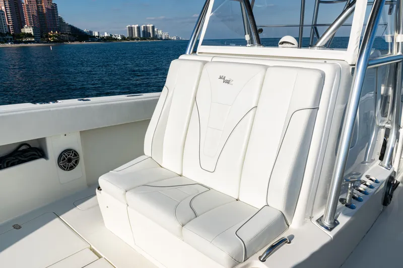 Slide: The Image of 2020 SeaVee 390Z boat with white seating, ocean view, and city skyline in the background. - 21