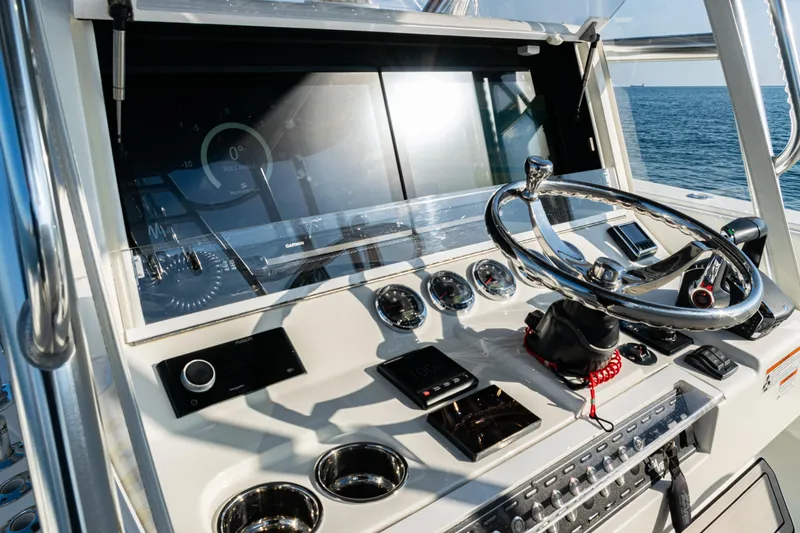 Slide: The Image of 2020 SeaVee 390Z boat dashboard with modern controls and steering wheel on open water. - 24