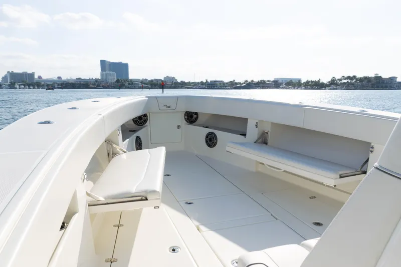 Slide: The Image of 2020 SeaVee 390Z boat interior with seating, on calm water, cityscape in background. - 7