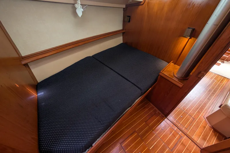 Slide: The Image of 1988 Island Packet 38 cabin interior with wooden flooring and cozy bed. - 10