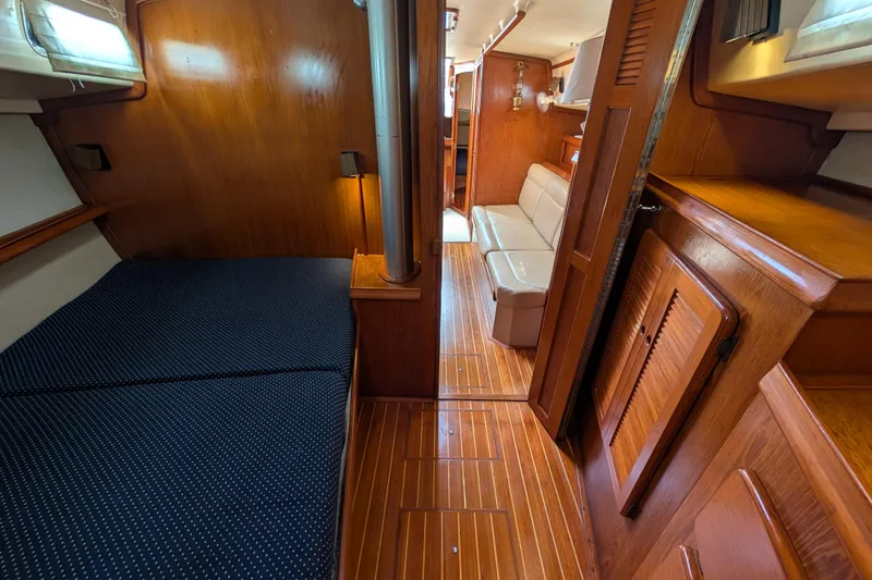 Slide: The Image of 1988 Island Packet 38 yacht interior with wooden finish, cozy seating, and sleeping area. - 11