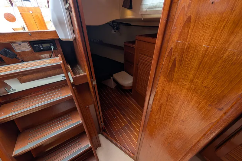 Slide: The Image of Interior of 1988 Island Packet 38 sailboat, featuring wooden stairs and cabin area. - 16