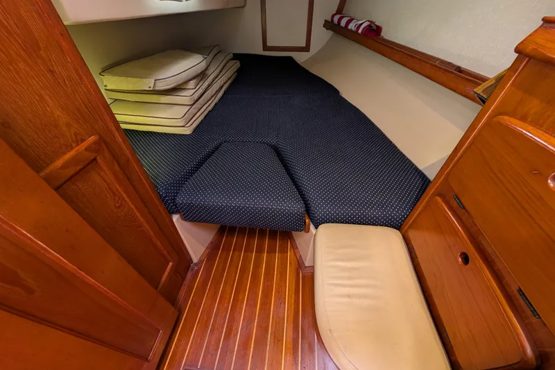 Slide: The Image of 1988 Island Packet 38 cabin interior with wooden finish and cushioned sleeping area. - 17