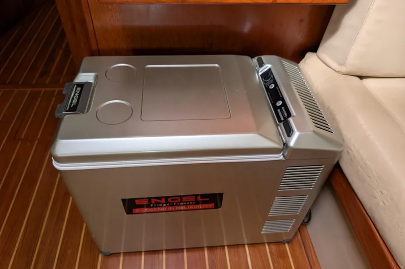 Slide: The Image of Engel fridge-freezer on 1988 Island Packet 38 yacht, wooden floor, beige seating. - 24