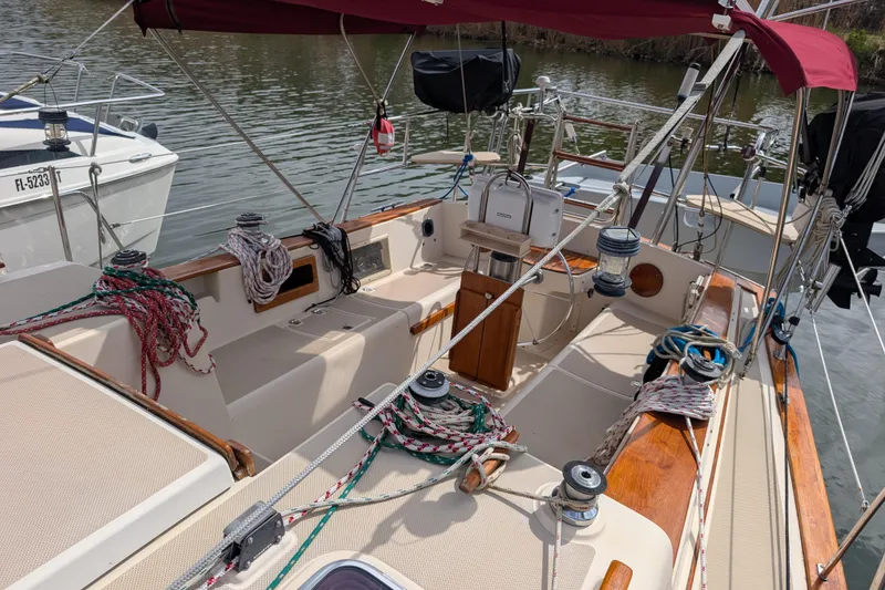 Slide: The Image of 1988 Island Packet 38 sailboat cockpit with ropes, winches, and wooden accents. - 26