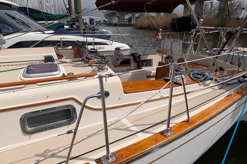 Slide: The Image of 1988 Island Packet 38 sailboat with polished wood deck, docked in a marina. - 27
