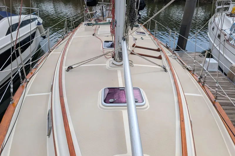 Slide: The Image of 1988 Island Packet 38 sailboat deck with wooden trim, docked at marina. - 34