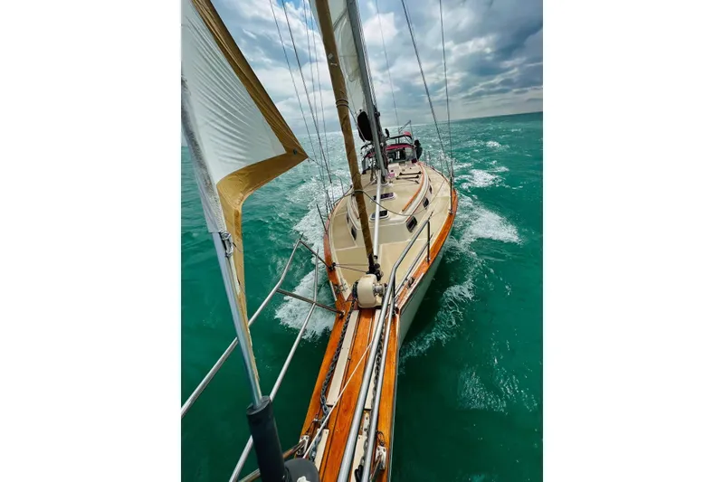 Slide: The Image of 1988 Island Packet 38 sailboat navigating turquoise waters under cloudy skies. - 43