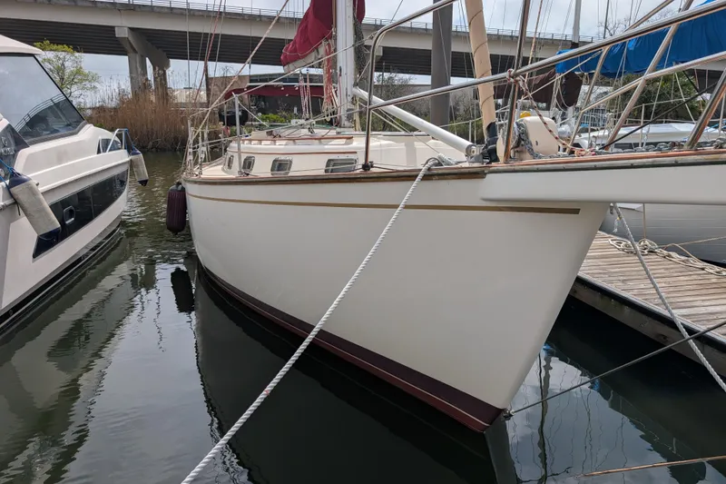 Slide: The Image of 1988 Island Packet 38 sailboat docked beside another vessel in a marina. - 47