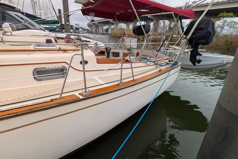 Slide: The Image of 1988 Island Packet 38 sailboat docked with red canopy and polished wood accents. - 49