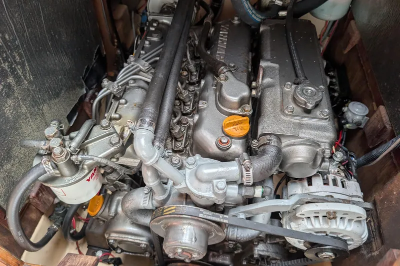 Slide: The Image of Engine of a 1988 Island Packet 38 sailboat, showcasing mechanical components and Yanmar filter. - 54