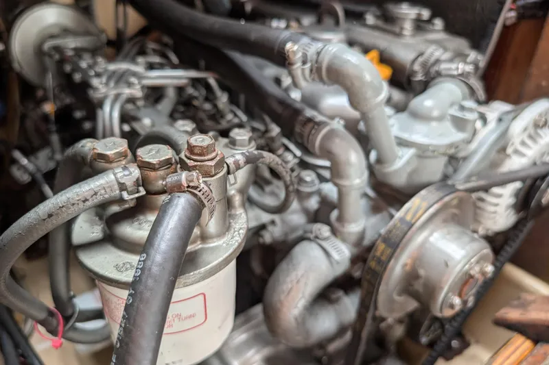 Slide: The Image of Engine components of a 1988 Island Packet 38 sailboat, showcasing hoses and mechanical parts. - 55